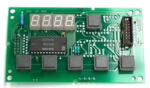 Leiterplatine von Daikin mit fünf Tasten, einem Mikrochip und einem Anzeigeelement, montiert auf einer grünen Platine mit elektrischen Verbindungen und Komponenten.